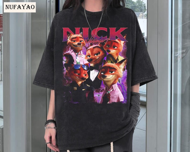 Op de afbeelding: Zwart T-shirt met een afbeelding van het personage Nick Wilde uit de animatiefilm Zootopia. De afbeelding toont Nick in verschillende poses met het woord "NICK" in rode letters. Het shirt heeft korte mouwen en een losse pasvorm.