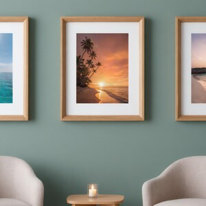 Può includere: Tre stampe da parete incorniciate con scene di spiagge tropicali. La stampa a sinistra mostra un oceano blu brillante, quella centrale un tramonto con palme e quella a destra una riva calma al crepuscolo, tutte in cornici di legno chiaro.