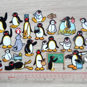 May include: A set of 28 colorful penguin stickers featuring various poses and activities, including holding a fish, a ball, a bucket, and a sign that says "Pingu".