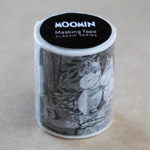 May include: A roll of Moomin masking tape from the Classic Series. The tape features a black and white illustration of two Moomin characters in a forest setting. The top of the roll has a black label with white text.