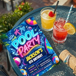 A neon blue and pink pool party invitation with glow-in-the-dark text, palm trees, and pool floats, lying on a black outdoor table next to two cocktails.