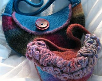 May include: A handmade felt handbag with a blue body and strap, a red button closure, and a multi-coloured striped design. A smaller, matching felt pouch with a ruffled edge is also visible.