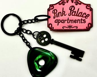 Engraved Cora inspired  Pink Palace keychain with green seeing stone and black button skeleton key detail