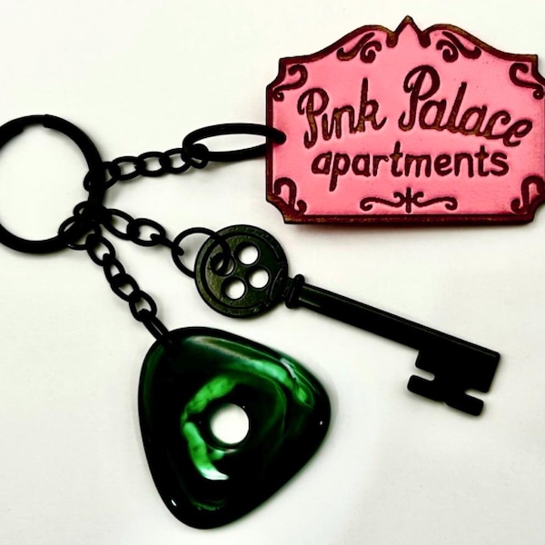 Engraved Cora inspired  Pink Palace keychain with green seeing stone and black button skeleton key detail
