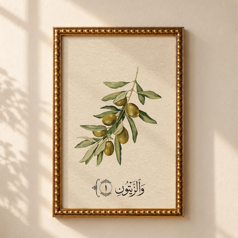 May include: A framed wall art print featuring a watercolor illustration of an olive branch with green leaves and olives on a cream background. Below the branch is the Arabic text "والزيتون" and the number 1 inside a decorative border.