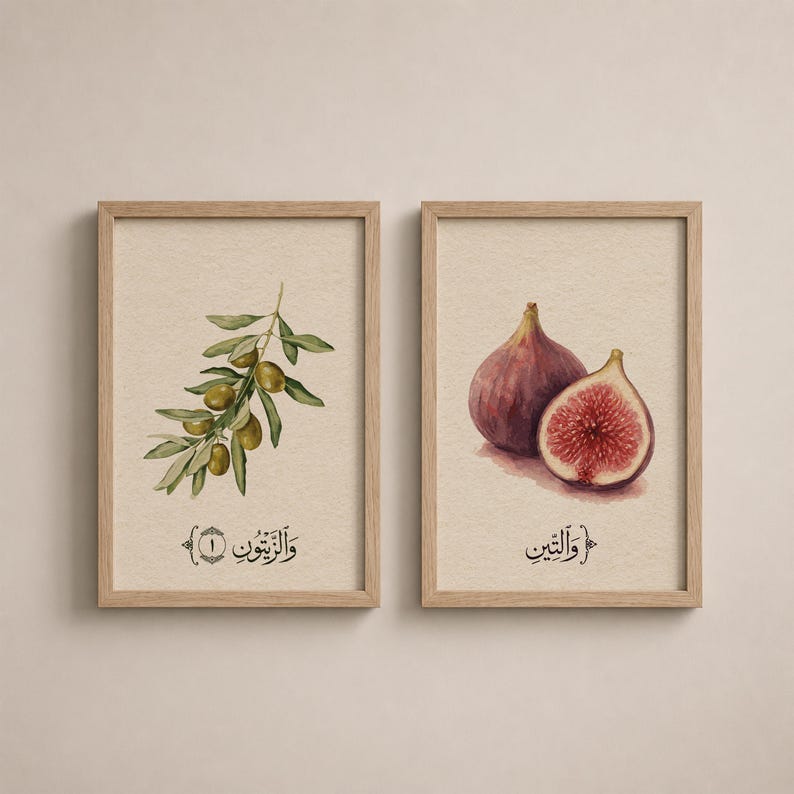 May include: Two framed wall art prints with light wood frames. The left print features a watercolor illustration of an olive branch with green olives and Arabic text. The right print shows a whole and a halved fig with Arabic text below.