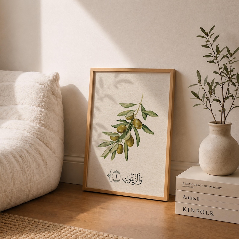 May include: A rectangular framed wall art print featuring a watercolor illustration of an olive branch with green olives and leaves. Below the branch, the Arabic text "والزيتون" is written in black calligraphy inside a decorative border.