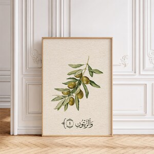 May include: A vertical rectangular wall art print on textured cream paper featuring a watercolor illustration of an olive branch with green leaves and several olives. Below the branch is black Arabic calligraphy text and the number one.