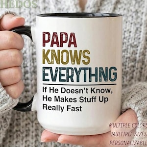 May include: White ceramic mug with a black handle and rim. The mug features the text "PAPA KNOWS EVERYTHING" in maroon, gold, and teal lettering. Below, it reads "If He Doesn't Know, He Makes Stuff Up Really Fast."