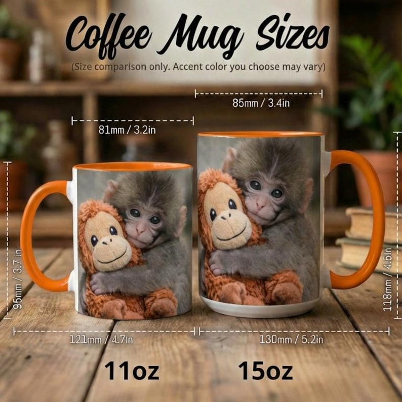 May include: Two ceramic coffee mugs with orange handles and rims. The mugs feature a print of a monkey hugging a stuffed animal monkey. The smaller mug is 9.5cm tall and 12.1cm wide, while the larger mug is 11.8cm tall and 13cm wide. Text on the image reads "Coffee Mug Sizes".
