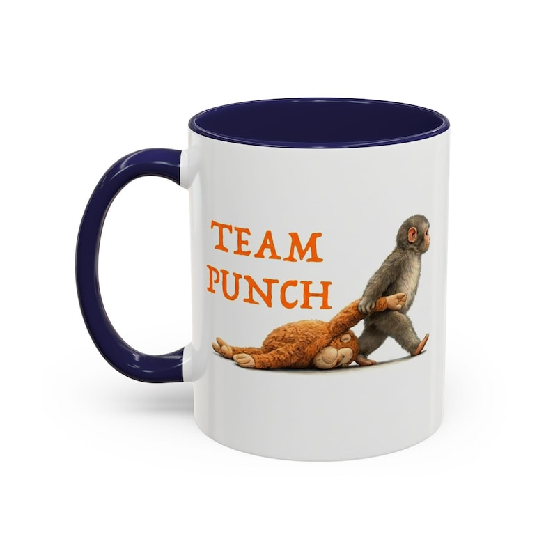 May include: A white ceramic mug with a black handle and the text "But First, Coffee" in a bold, black font. The mug is set against a blurred background, suggesting a cozy setting. The mug appears to be approximately 4 inches tall.