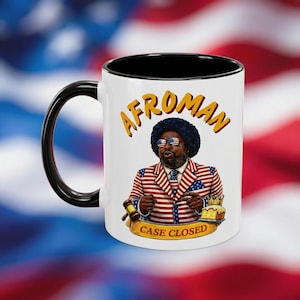 Puede incluir: Una taza de cerámica blanca con asa negra y el texto "But First, Coffee" en negrita negra. La taza está llena de un líquido oscuro, probablemente café, y se encuentra sobre una superficie clara.