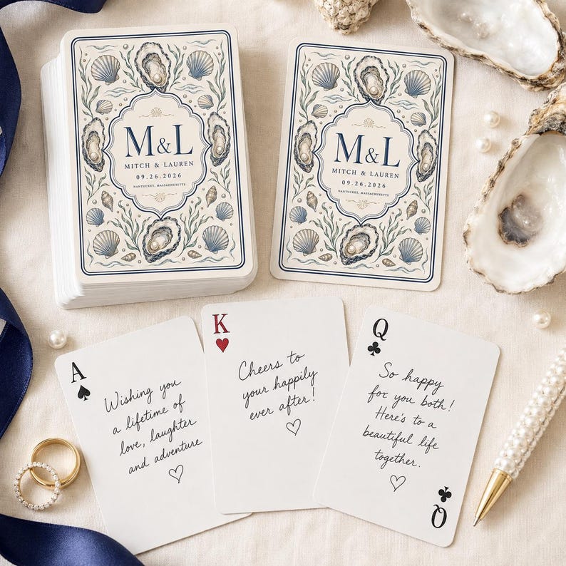 Pu&ograve; includere: Un mazzo di carte da gioco personalizzato con un'illustrazione di ostriche e conchiglie con il testo M&L, Mitch & Lauren e 09.26.2026. Tre carte singole mostrano messaggi scritti a mano, tra cui Cheers to your happily ever after e So happy for you both.