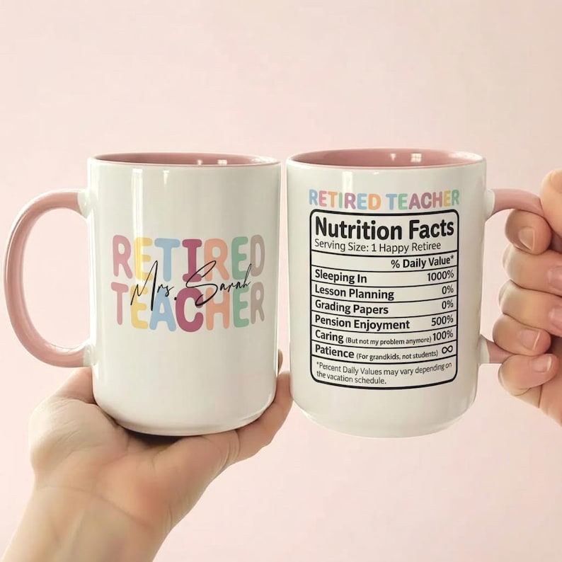 K&ouml;nnte beinhalten: Wei&szlig;er Keramikbecher mit rosa Griff und Innenraum. Der Becher tr&auml;gt den Text "RETIRED TEACHER" in bunten Buchstaben, darunter "Mrs. Sarah". Die andere Seite hat ein "Nutrition Facts"-Etikett f&uuml;r einen gl&uuml;cklichen Rentner.