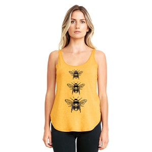 May include: A mustard yellow tank top with a black graphic of three bees in a vertical line.