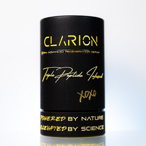 May include: A black cylindrical product container with gold lettering. The text on the container reads "CLARION", "Triple Peptide Infused", and "POWERED BY NATURE ELEVATED BY SCIENCE". The container has a textured surface and a white background.