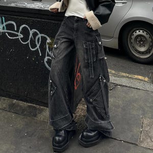 Women's Baggy Cargo Pants | Oversized Loose Washed Denim Jeans | Streetwear Punk Y2k Fashion
.
Women's oversized baggy denim cargo pants with wide-leg fit, zipper details, and multiple pockets — styled for punk and Y2K streetwear fashion.
