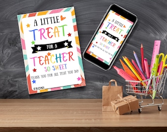 以下が含まれることがあります： 「A Little Treat for a Teacher So Sweet」というテキストが表示されたカラフルなギフトカードとスマートフォン。カードと電話は、学校用品やギフトを背景にした木製の表面にあります。