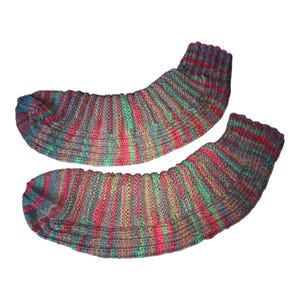 May include: A pair of knitted socks with a striped pattern in red, green, and blue. The socks have ribbed cuffs and a foot area. These handmade socks are designed for warmth and comfort. The socks are a cozy accessory.