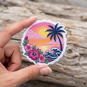 May include: Embroidered patch featuring a tropical beach scene. The design includes a sunset with a yellow sun, pink clouds, and a palm tree. Pink hibiscus flowers and blue waves complete the design, all within a scalloped border.