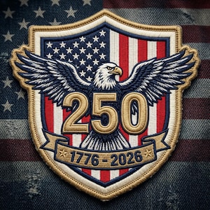 May include: Embroidered patch featuring a shield design with the American flag, an eagle with outstretched wings, and the number "250" in gold. The banner below reads "1776-2026". The patch has a gold border and is set against a denim background.