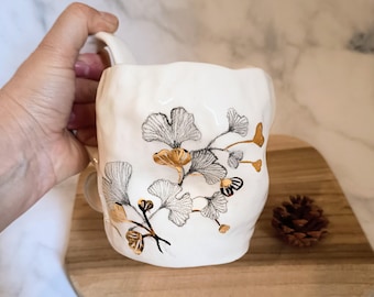 Ceramic mug with hand-painted ginkgo leaves and real gold accents, handmade in Italy