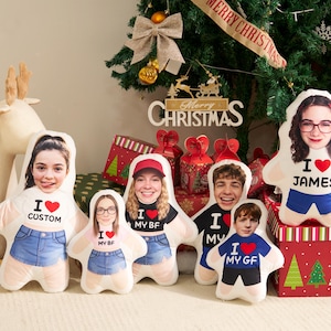May include: A collection of five custom-shaped plush pillows featuring printed photographs of faces on the upper portion and graphic text including I heart CUSTOM, I heart MY BF, I heart MY GF, and I heart JAMES on the lower torso area.