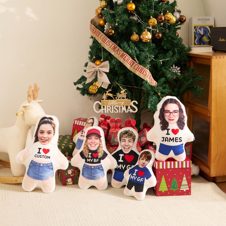 May include: Five custom-shaped plush pillows featuring printed photographs of people's faces on cartoon-style bodies. Each pillow displays text including I LOVE CUSTOM, I LOVE MY BF, I LOVE MY GF, and I LOVE JAMES with red heart icons.