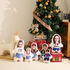 May include: A collection of five custom-shaped plush pillows featuring printed portraits of individuals wearing shirts with the text I heart CUSTOM, I heart MY BF, I heart MY GF, and I heart JAMES, with red heart icons and blue denim shorts.