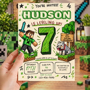 May include: A rectangular birthday invitation card with a cream background featuring green text and illustrations. It displays the text YOU'RE INVITED! HUDSON IS LEVELING UP! 7, EAT PLAY EXPLORE CELEBRATE!, and party details including date, time, and address.