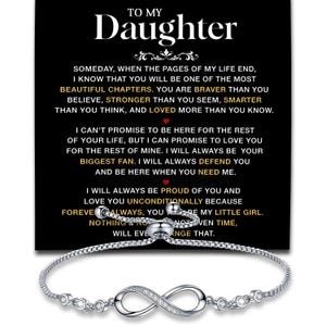 May include: A silver-toned adjustable bracelet featuring an infinity symbol centerpiece accented with small clear stones. The bracelet is displayed against a black card with white and gold text that reads To My Daughter and includes a sentimental message.