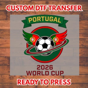 May include: A DTF transfer design with a football, wings in the colours of the Portuguese flag, and the text "PORTUGAL" and "2026 WORLD CUP". The design is ready to press.