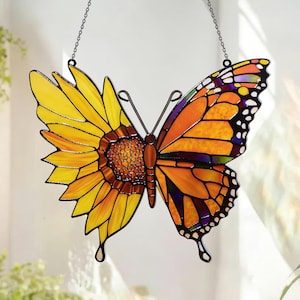 Può includere: Acchiappasole a farfalla in vetro colorato, con un design a metà girasole e a metà farfalla monarca. Il lato del girasole è giallo e arancione, mentre il lato della farfalla è arancione, viola e bianco. Appeso a una catena.