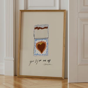 painting style trendy vintage style matchbook showing a sacred heart and below it says "you light me up" a romantic wall art print for modern living room or gallery wall by Stephie Cardona for KunstbyStephie