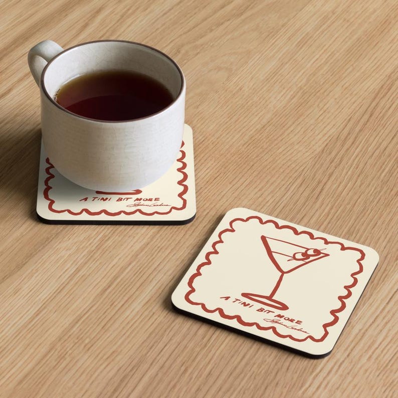May include: Two square coasters with a cream background and a red scalloped border. One coaster has a martini glass illustration, the other has a mug of tea. Both have the text "A Tini Bit More" and a signature.