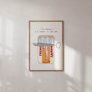 Chic Hand-drawn minimalist kitchen and bar cart print "Sardines" art print poster by KunstbyStephie. A framed print of a sardine can with a can opener sticking out of the top. The can is labeled 'French Sardines' and has a yellow background with red text. The text above the can reads 'Sardines de la conserve de salt-water.'