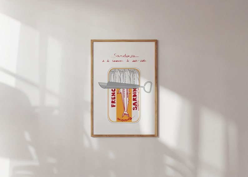Chic Hand-drawn minimalist kitchen and bar cart print "Sardines" art print poster by KunstbyStephie. A framed print of a sardine can with a can opener sticking out of the top. The can is labeled 'French Sardines' and has a yellow background with red text. The text above the can reads 'Sardines de la conserve de salt-water.'