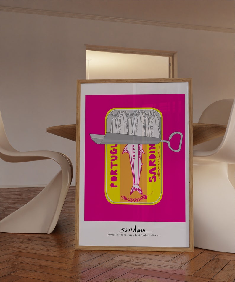 May include: A framed rectangular art print featuring a vibrant magenta background and a central yellow sardine tin illustration. The graphic depicts stylized fish, a metal lid, and the text PORTUGUESE SARDINES. Below, the text reads sardines Straight from Portugal, kept fresh in olive oil.