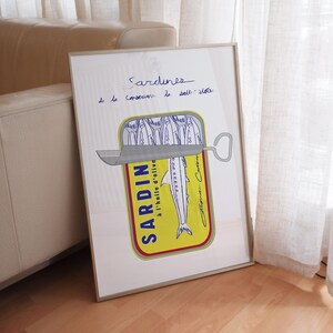 minimalistic nautical beachy poster in white showing hand drawn sketch of a tin of sardines in yellow with blue script typography