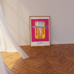 May include: A framed rectangular art print featuring a vibrant pink background with a yellow sardine tin illustration. The tin shows silver sardines, a metal lid, and the text PORTUGUESE SARDINES. The bottom text reads sardines straight from Portugal.
