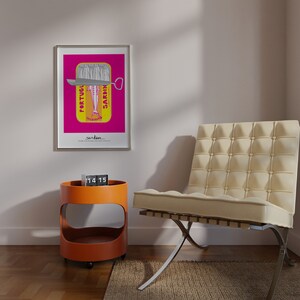 May include: A framed wall art print featuring a vibrant magenta background with a yellow sardine tin graphic. The tin displays the text PORTUGUESE SARDINES and a stylized fish illustration. Below the tin, the word sardines is printed in black text.