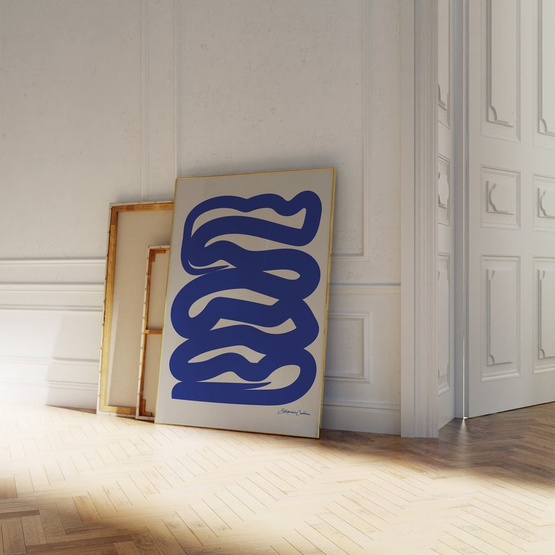 May include: A framed abstract art print with a blue and white color scheme. The print features a series of wavy lines in a blue color against a white background.