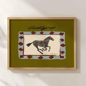 Puede incluir: L&aacute;mina art&iacute;stica enmarcada con una ilustraci&oacute;n de un caballo corriendo. La obra de arte tiene un fondo verde con un dise&ntilde;o rectangular en azul y marr&oacute;n. Las palabras "Giddy-up" est&aacute;n escritas en cursiva en la parte superior.