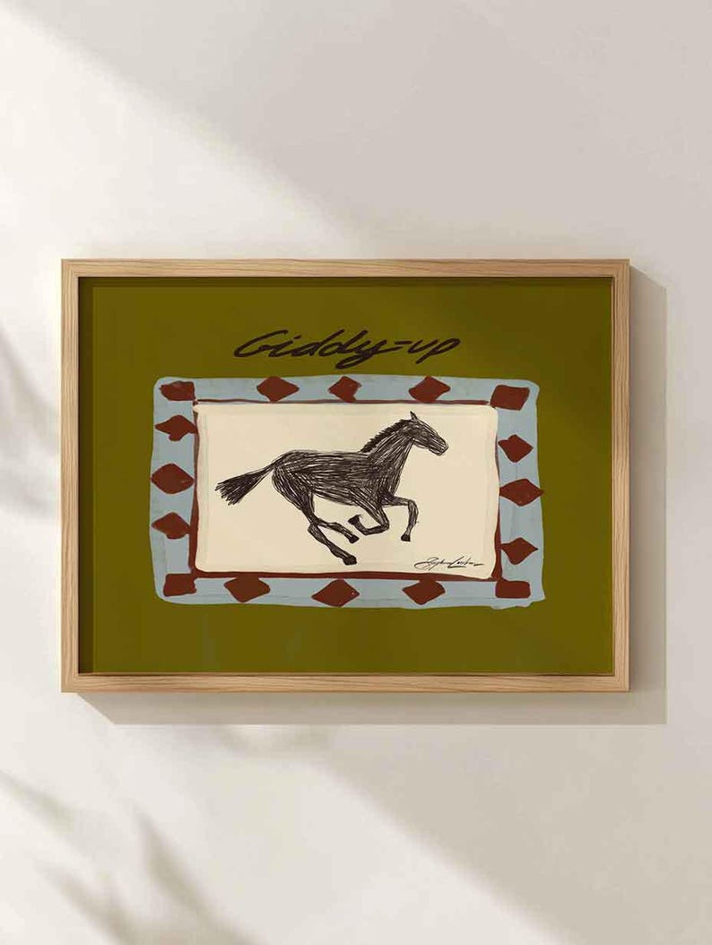 Puede incluir: L&aacute;mina art&iacute;stica enmarcada con una ilustraci&oacute;n de un caballo corriendo. La obra de arte tiene un fondo verde con un dise&ntilde;o rectangular en azul y marr&oacute;n. Las palabras "Giddy-up" est&aacute;n escritas en cursiva en la parte superior.