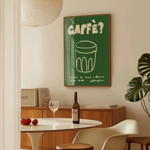 Op de afbeelding: Een witte keramische mok met een zwart handvat en de tekst "But First, Coffee" in een zwarte, handgeschreven lettertype. De mok staat op een wit oppervlak.