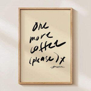 Puede incluir: Impresi&oacute;n art&iacute;stica enmarcada con la frase "One more coffee (please) x" en trazos negros sobre fondo crema. La impresi&oacute;n est&aacute; en un marco de madera clara, adecuada para la decoraci&oacute;n de cocina o comedor.
