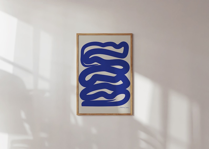 May include: A framed abstract print with a blue, wavy design on a cream background. The print is in a wooden frame.