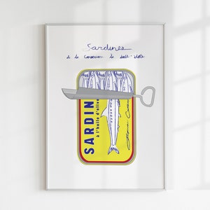 Chic Hand-drawn minimalist kitchen and bar cart print "Sardines" art print poster by KunstbyStephie. A framed print of a yellow sardine can with a blue and white label that reads 'SARDIN à l'huile d'olive.' The can is partially open with a silver can opener. The print has the words 'Sardines de la Conserverie le Boll - île' written in blue ink at the top.