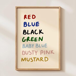 以下が含まれることがあります： クリーム色の背景に「RED」、「BLUE」、「BLACK」、「GREEN」、「BABY BLUE」、「DUSTY PINK」、「MUSTARD」の文字が様々な色で手書きされた、額入りのアートプリントです。