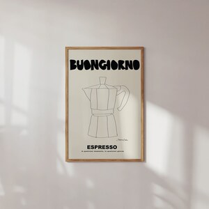 May include: A framed wall art print featuring a black line drawing of a moka pot centered on a cream background. The text BUONGIORNO appears in large black letters at the top, with ESPRESSO and smaller Italian text printed below the coffee maker.